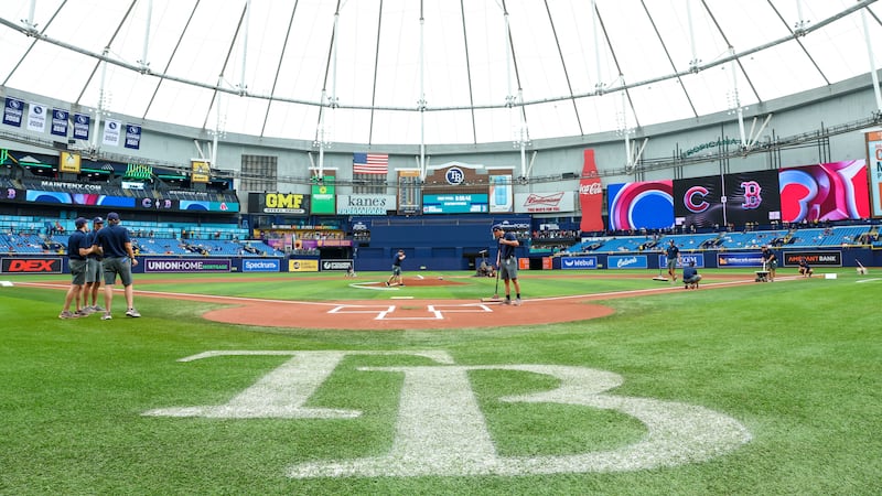 Crews prepare the field for a baseball game between the Chicago Cubs and the Boston Red Sox at...